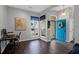 Inviting entryway with a vibrant blue door, hardwood floors, and a convenient home office setup at 8506 Kennestone Ln, North Charleston, SC 29420