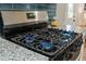 Close up of a stainless steel gas range with blue flames and granite countertops at 914 King Richard Dr, Charleston, SC 29407
