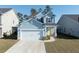 Charming two-story blue home featuring an attached garage, yellow front door, and well-maintained landscaping at 103 Cotesworth Ct, Summerville, SC 29486