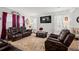 Cozy living room boasting comfortable brown leather seating, a plush rug, and elegant decor at 103 Cotesworth Ct, Summerville, SC 29486