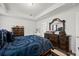 Comfortable bedroom with blue bedding, tray ceilings, dark wood dressers, and an ornate mirror at 103 Cotesworth Ct, Summerville, SC 29486
