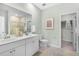 Bright bathroom with double sink vanity, tile floors, framed art, and walk in closet at 1047 Tea Time Dr, Summerville, SC 29485