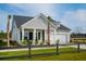 Inviting home exterior with black fence, manicured lawn and elegant landscaping with young palm trees at 1047 Tea Time Dr, Summerville, SC 29485