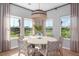 Bright dining area with views of backyard, a woven pendant light, and a modern round table with six chairs at 1058 Tea Time Dr, Summerville, SC 29485