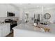 Modern kitchen features white cabinets, stainless steel appliances, and an island with a sink and quartz countertop at 1058 Tea Time Dr, Summerville, SC 29485
