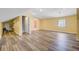 Spacious bonus room with ample lighting, wood-look flooring, and sunny yellow walls at 107 Minus St, Saint George, SC 29477