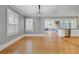 Bright dining room featuring hardwood floors, a modern light fixture, and an open layout with connecting rooms at 107 Minus St, Saint George, SC 29477