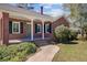 Close-up of brick home featuring the front porch, blue front door, shutters, and landscaped walkway at 107 Minus St, Saint George, SC 29477