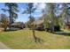 A charming brick home is nestled among mature trees with a lush front yard, showcasing its inviting curb appeal at 107 Minus St, Saint George, SC 29477