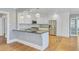 Modern kitchen with a breakfast bar, white cabinetry, stainless steel appliances, and hardwood floors at 107 Minus St, Saint George, SC 29477