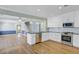 Open kitchen with white cabinetry, stainless appliances, and breakfast bar overlooking adjacent rooms at 107 Minus St, Saint George, SC 29477