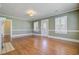 Inviting living room with hardwood floors, neutral paint, and ample natural light from white-shuttered windows at 107 Minus St, Saint George, SC 29477