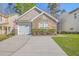 Charming home featuring a stone facade, well-manicured lawn, and a garage with white doors at 108 Chemistry Cir, Ladson, SC 29456