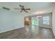 Open-concept living room with hardwood floors, a ceiling fan, and an adjacent kitchen at 108 Chemistry Cir, Ladson, SC 29456