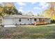 Charming single-story home with light gray siding, a front deck, and a manicured lawn with updated landscaping at 1174 Fort Johnson Rd, James Island, SC 29412