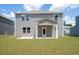 Exterior backyard view showcases a home with gray siding, a covered patio and green lawn at 123 Royal Cainhoy Way, Huger, SC 29450