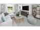 Bright living room boasts large windows, herringbone accent wall, modern furnishings, and stylish decor at 123 Royal Cainhoy Way, Huger, SC 29450
