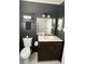 A modern bathroom features dark walls, white tile floors, a vanity, and elegant fixtures at 1236 Fort Dr, Hanahan, SC 29410