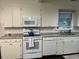 Kitchen features white appliances, cabinets, and granite countertops, complemented by subway tile backsplash at 1236 Fort Dr, Hanahan, SC 29410