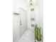 Well-lit entryway with light tile floors, featuring a coat rack and plant, creating a neat and inviting first impression at 1325 Telfair Way, Charleston, SC 29412