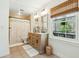 Bathroom featuring a double vanity, a window and a tiled shower with a decorative curtain at 1515 Devons St, Charleston, SC 29412