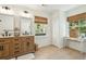 Bright bathroom with double vanity, tile flooring, and natural light from two windows at 1515 Devons St, Charleston, SC 29412