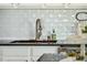 The kitchen sink features a stainless steel faucet and a view of a tiled backsplash and dark countertops at 1515 Devons St, Charleston, SC 29412