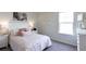 Bright bedroom features neutral walls, gray carpet, a comfortable bed with throw pillows, and a horse art piece at 182 E Pinckney St, Lincolnville, SC 29485