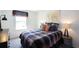 Cozy bedroom with a plaid comforter, world map decor, and a window allowing natural light to illuminate the room at 182 E Pinckney St, Lincolnville, SC 29485