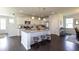 Open concept kitchen featuring an island with barstool seating, white cabinets and stainless steel appliances at 182 E Pinckney St, Lincolnville, SC 29485