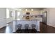 Well lit kitchen with granite countertops, stainless steel appliances, a kitchen island and three barstools at 182 E Pinckney St, Lincolnville, SC 29485