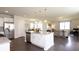 Bright kitchen featuring white cabinets, a large island with granite countertops, and stainless steel appliances at 182 E Pinckney St, Lincolnville, SC 29485