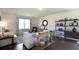 Living room featuring hardwood floors, natural light, and comfortable seating with decorative shelving at 182 E Pinckney St, Lincolnville, SC 29485
