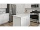 A modern kitchen with white cabinets, stainless steel appliances, and a central island with a white countertop at 1827 Nola Run, Summerville, SC 29485