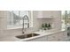 Close-up of kitchen sink and window with a view, accented by light countertops and white cabinets at 1827 Nola Run, Summerville, SC 29485