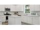A modern kitchen with white cabinets, stainless steel appliances, and a central island with a white countertop at 1827 Nola Run, Summerville, SC 29485