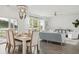 Open-concept living and dining area with modern light fixtures and large windows offering scenic outdoor views at 1827 Nola Run, Summerville, SC 29485