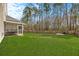 Expansive backyard featuring lush green grass, a screened-in patio, and mature trees for added privacy at 184 Charlesfort Way, Moncks Corner, SC 29461