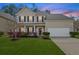Charming two-story home featuring a well-manicured lawn, flowering bushes, and an attached two-car garage at 184 Charlesfort Way, Moncks Corner, SC 29461