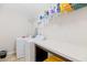 Bright laundry room with a white washer and dryer, counter space, and overhead shelving at 184 Charlesfort Way, Moncks Corner, SC 29461