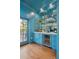Stylish bar with a wine fridge, mirrored backsplash, and blue cabinets at 184 Tradd St, Charleston, SC 29401