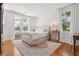 Sunlit bedroom featuring hardwood floors, large windows with drapes, and a cozy rug at 184 Tradd St, Charleston, SC 29401