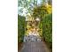 Ornate wrought iron gate surrounded by lush greenery leads to a tranquil garden with a fountain at 184 Tradd St, Charleston, SC 29401