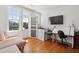 Bright office with a sofa, large window, and desk space with contemporary design and hardwood floors at 184 Tradd St, Charleston, SC 29401