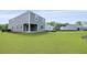A generous green lawn shows the back of a gray, two-story home with classic siding and covered patio at 194 E Pinckney St, Lincolnville, SC 29485