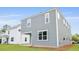Back of gray, two-story home featuring classic siding, white trim, and an inviting covered patio at 194 E Pinckney St, Lincolnville, SC 29485