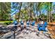 Outdoor area includes a gravel fire pit with blue Adirondack chairs in a wooded backyard at 2107 Nicholas David Path, Johns Island, SC 29455