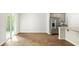 View of open floor plan from kitchen to dining area, featuring wood-look floors and stainless appliances at 2179 Macallan Blvd, Ravenel, SC 29470