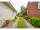 View of backyard with shed between white brick and red brick home at 223 Grove St, Charleston, SC 29403