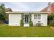 Charming home exterior with brick, white walls, a blue door, awning, and green grass at 223 Grove St, Charleston, SC 29403